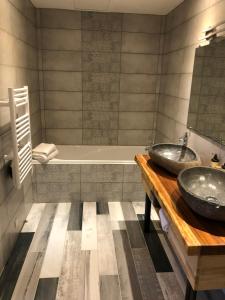 a bathroom with two sinks and a tub at Logis Hôtel Le Moulin de Chalons in Le Gua +52 photos