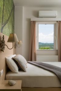 a bedroom with a large bed with a window at Majestic Villa-Apartments in Darmarochori