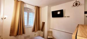 a bedroom with a window and a television on the wall at Appartamento indipendente Vittorio in Cagliari