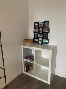 une étagère blanche avec des livres sur elle dans l'établissement Studio Meublé Vue Mer, au Havre