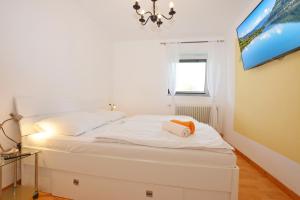 a small bedroom with a white bed and a window at Ferienwohnung Alpenblick in Villach