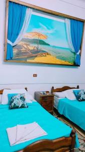 a room with two beds and a picture of a beach at Acropole Hotel in Alexandria