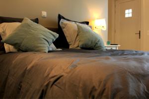 a bedroom with a large bed with pillows at B&B Laurus in Ieper