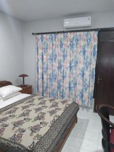 1 dormitorio con cama y ventana con cortina en Bali Senia Hotel, en Sanur
