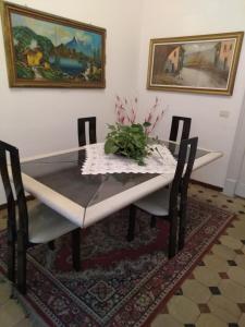 een eettafel en stoelen met een vaas erop bij House Vintage in Catania