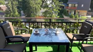 a blue table with cups and saucers on a balcony at Apartman Zlaja Vlašić in Vlasic +25 photos