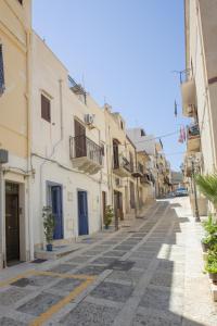 an empty street in a town with white buildings at Al Baglio in Castellammare del Golfo