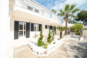 una casa blanca con persianas y plantas negras en Residence Paradise, en Peschici