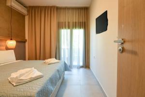 a bedroom with a bed with two towels on it at Zinozis Beach Apartments in Vourvourou