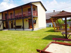 a house with a deck and a picnic table in a yard at Цвіт лілії in Szack