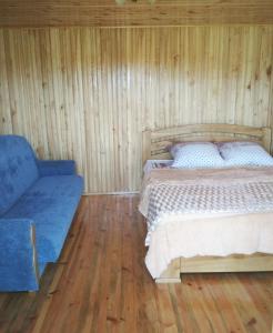 a bedroom with a bed and a couch at Цвіт лілії in Szack