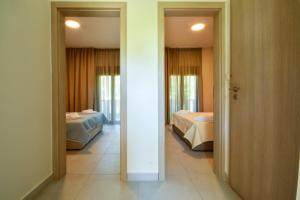a room with two beds and a hallway with two beds at Zinozis Beach Apartments in Vourvourou