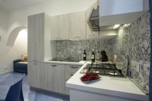 a kitchen with a stove and a bowl of fruit on a counter at Al Baglio in Castellammare del Golfo