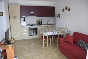 a kitchen with a table and a red couch in a room at La Terrazza sul Lago in Malcesine
