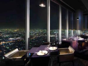 a restaurant with a view of a city at night at Osaka Marriott Miyako Hotel in Osaka