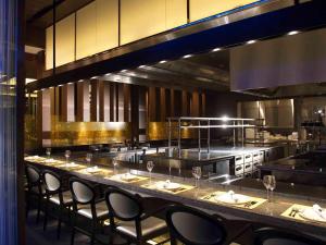 a restaurant with a long bar with chairs in it at Osaka Marriott Miyako Hotel in Osaka