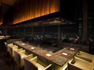 a long table in a restaurant with a view of a city at Osaka Marriott Miyako Hotel in Osaka