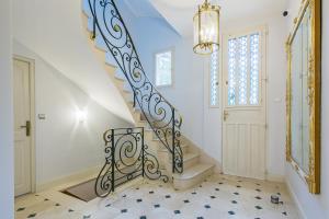 a staircase in a home with a chandelier at Le Clos du Cèdre in Saint-Ouen