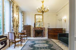 a living room with a fireplace and a mirror at Le Clos du Cèdre in Saint-Ouen