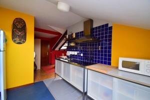 a kitchen with blue and yellow walls and a microwave at Apartamento Loft in Navia