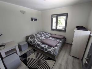 een kleine slaapkamer met een bed en een raam bij Mazury domek całoroczny Pelnik gm Ostróda jezioro las in Pelnik