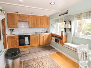 a kitchen with wooden cabinets and a sink at The Barn in Dalbeattie