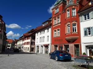 阿爾高地區旺根的住宿－Ferienwohnung Kitzelmann，停在街道上的蓝色汽车,有建筑