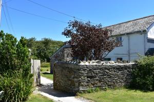 una pared de piedra frente a una casa en The Nook B&B en Port Isaac