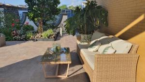 um sofá de vime e uma mesa no pátio em Sorrento Garden Room em Sorrento