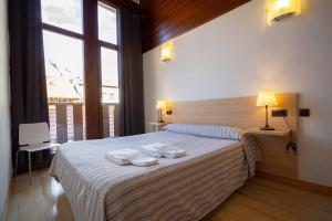 una camera da letto con un grande letto con asciugamani di Metsola Apartamentos Rurales a Isaba