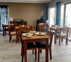 巴莉斯的住宿－Casa Cara Guest House，用餐室配有木桌和椅子