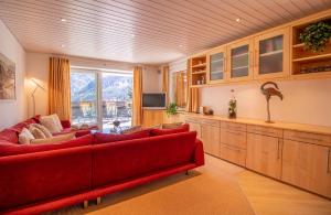 a living room with a red couch and a television at Sans Souci EG in Arosa