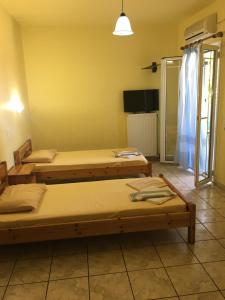 a room with two beds and a television in it at Pension Maria in Lefkada Town