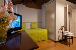 a living room with a television and a bed in a room at Agriturismo Le 4 Rose in Vescovana