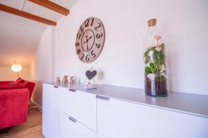 阿羅薩的住宿－Sans Souci OG，客厅配有白色橱柜和墙上的时钟