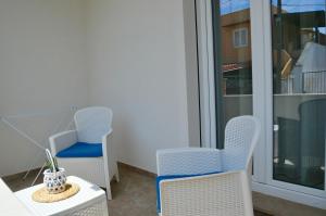 Un balcón con dos sillas y una mesa y una ventana. en B&B MarAlè, en Porto Cesareo