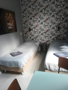 a room with two beds and a painting of a lion at Simplon Hostel in Groningen