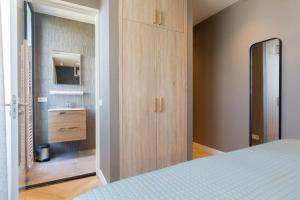 een slaapkamer met een bed, een wastafel en een spiegel bij BizStay Maurits in Den Haag
