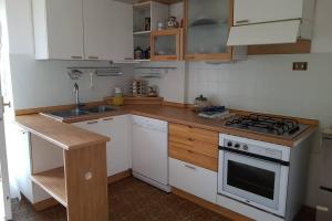a kitchen with white cabinets and a stove top oven at Casa da Rina in Siror