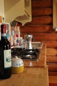 een fles wijn op een aanrecht naast een fornuis bij B&B Le Corone - Chalet nel Bosco in Cavalo