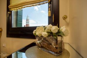 um vaso cheio de flores brancas sentado numa mesa em Relais Venezia em Veneza