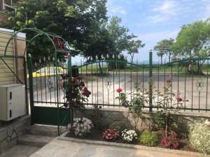 a gate with flowers on it next to a street at Апартамент Върбанови in Pomorie