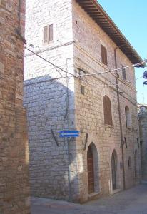 ein Backsteingebäude mit einem blauen Straßenschild davor in der Unterkunft Nice Assisi in Assisi