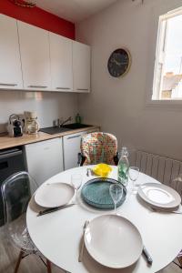 una cocina con una mesa con platos y vasos. en DUPLEX LE SAINT JEAN en Saumur