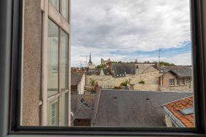 una ventana con vistas a la ciudad desde un edificio en DUPLEX LE SAINT JEAN en Saumur