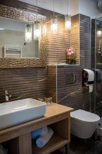 a bathroom with a sink and a toilet and a mirror at Hotel Meduza in Senj