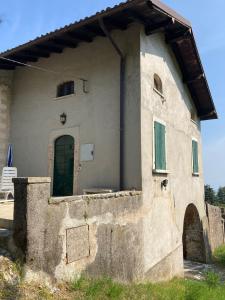 a small building with a green door on the side at Casa Milanda in Gargnano