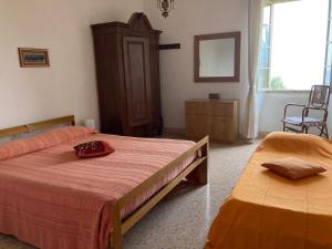 a bedroom with two beds and a mirror on the wall at Casa Milanda in Gargnano