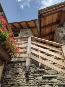 una escalera de madera en el lateral de un edificio de piedra en Le Baite di Baudinet - Trek&Relax, en Chiusa di Pesio