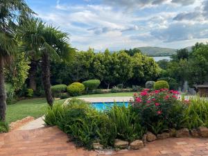 a garden with a swimming pool and flowers at Cozy Coleman in Hartbeespoort